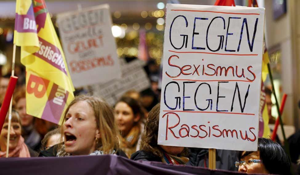 Women shout slogans and hold up a placard that reads "Against Sexism - Against Racism" as they march through the main railways station of Cologne, Germany, on January 5 (Reuters)