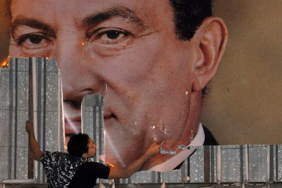 An anti-government protester defaces a picture of Egypt's President Hosni Mubarak in Alexandria on January 25, 2011. Photo: Stringer, Reuters