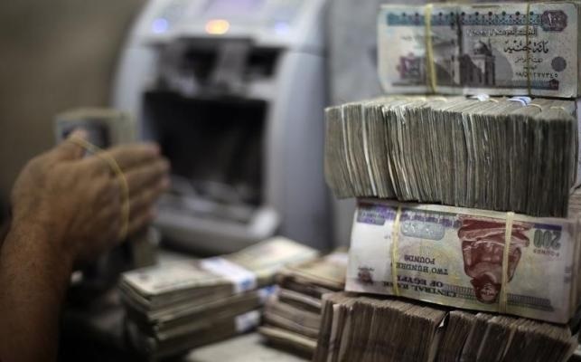 An employee counts money at an exchange office in downtown Cairo Credit: Amr Abdallah Dalsh/ Reuters