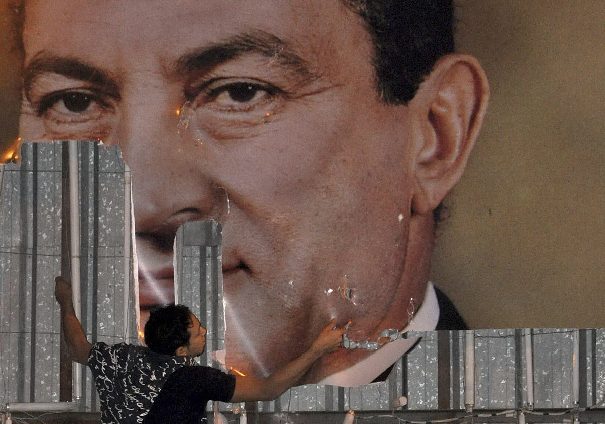 An anti-government protester defaces a picture of Egypt’s President Hosni Mubarak in Alexandria on January 25, 2011. Photo: Stringer, Reuters