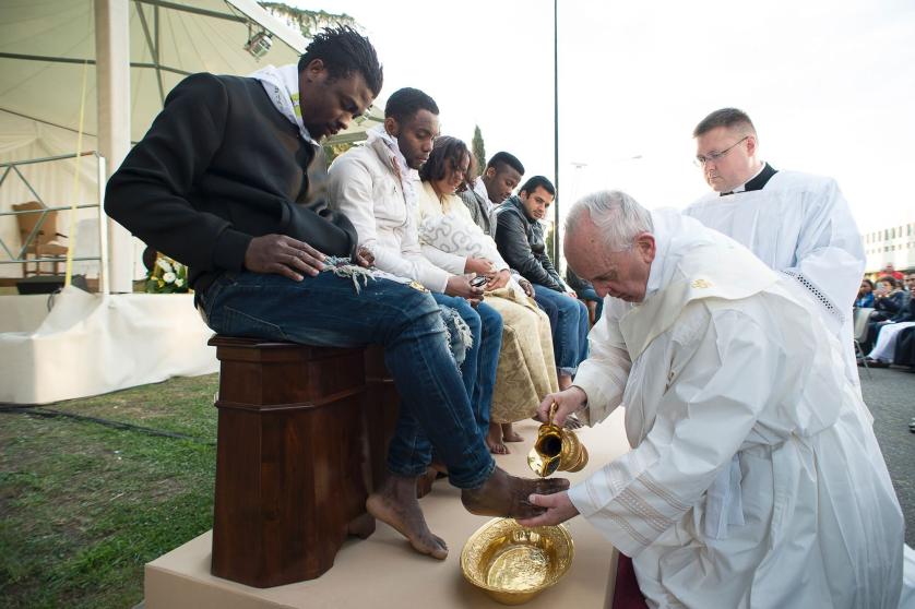 In this handout picture released by the Vatican Press Office, Pope Francis performs the foot-washing ritual at the Castelnuovo di Porto refugees center near Rome on March 24, 2016.