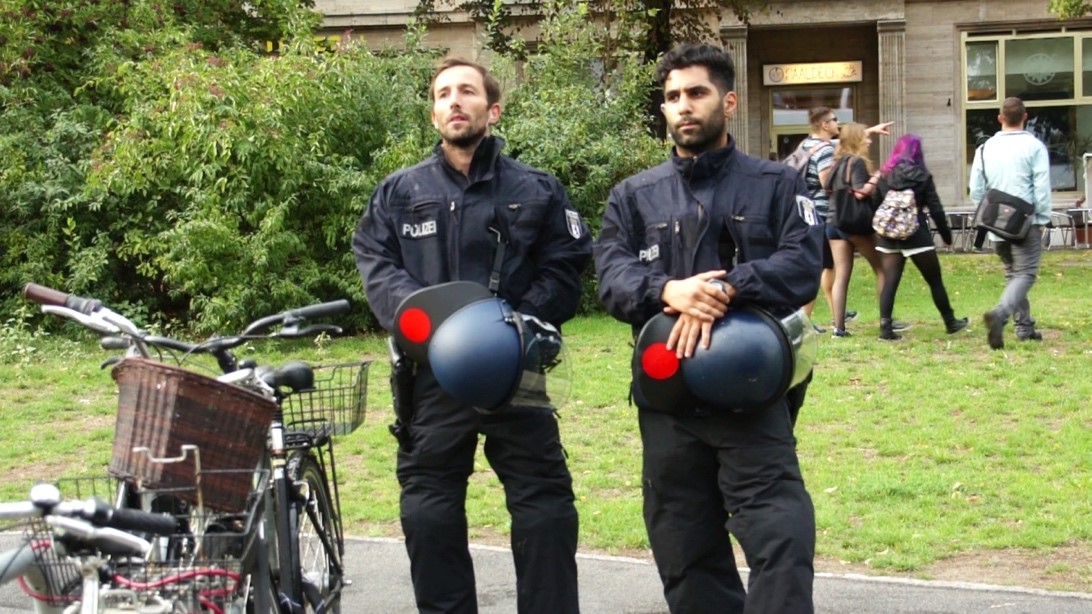 Policemen watching the Berliner love parade on Frankfurter Allee, Berlin (Photo: Ahmed Yacoub)