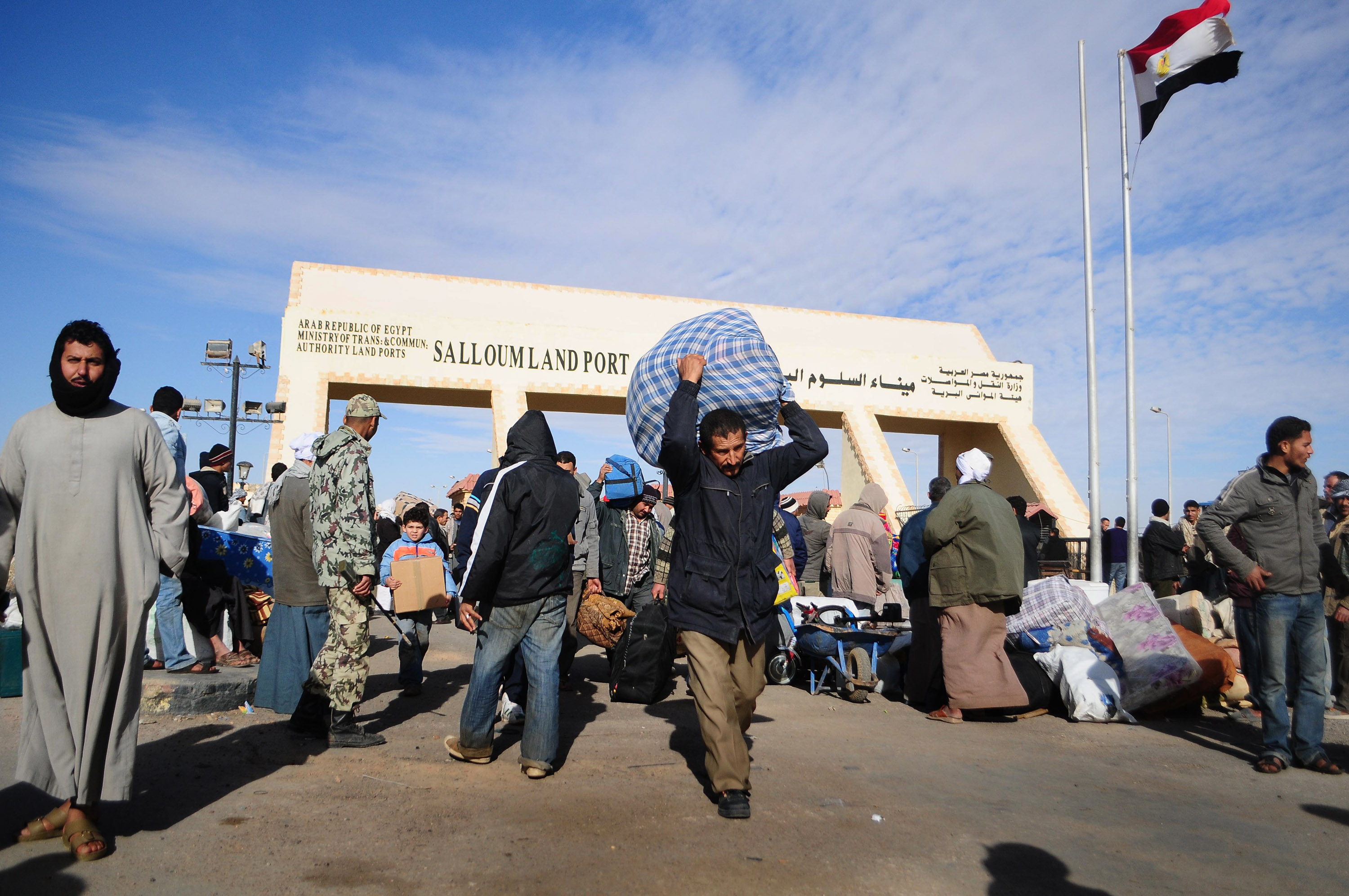 Egyptians carry their belongings as they transit the Sallum border crossing with Libya on February 23, 2011. Photo: Tarek Elframawy