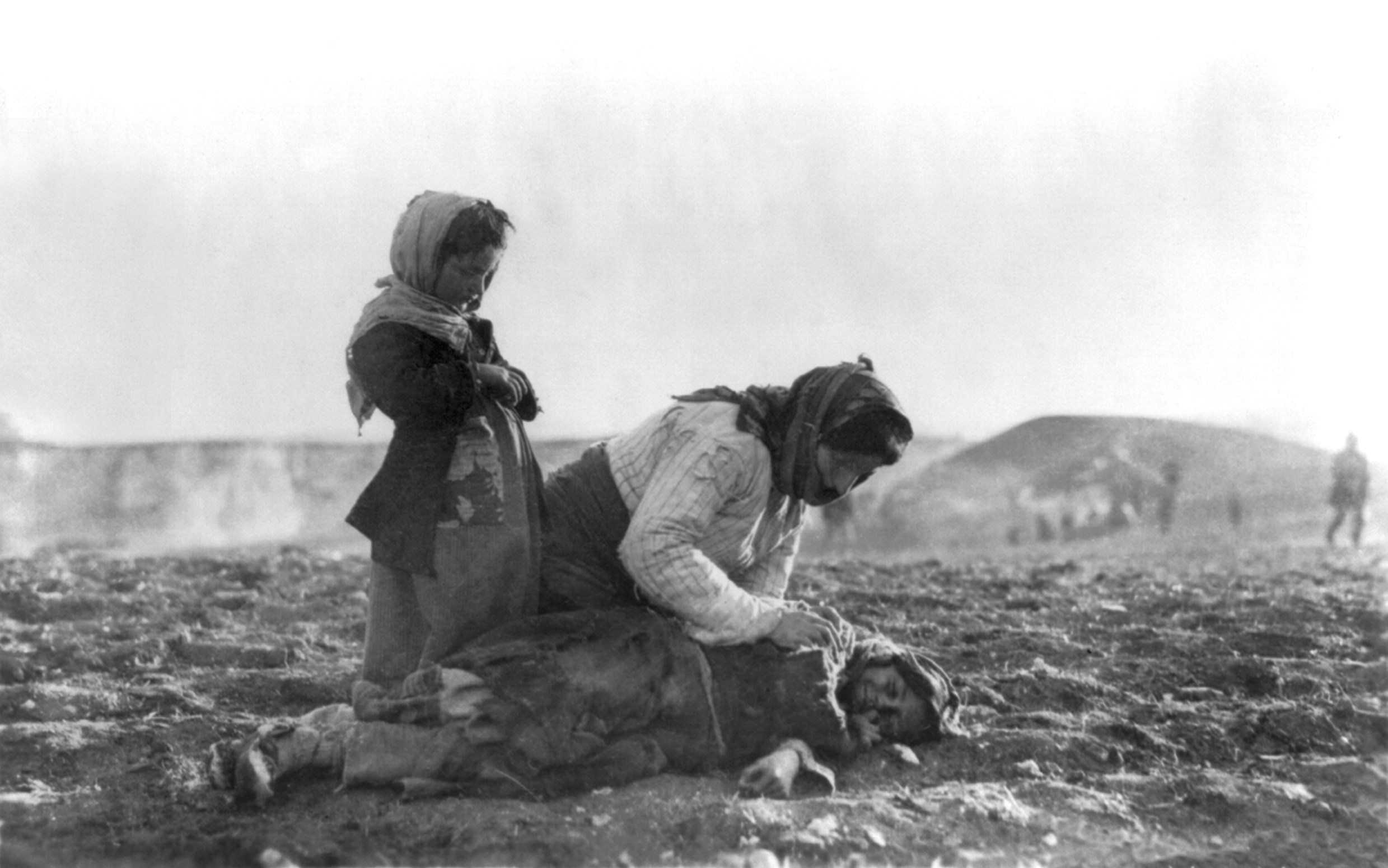 An Armenian woman kneeling beside a dead child in field "within sight of help and safety at Aleppo" (Credit: Wikicommons)