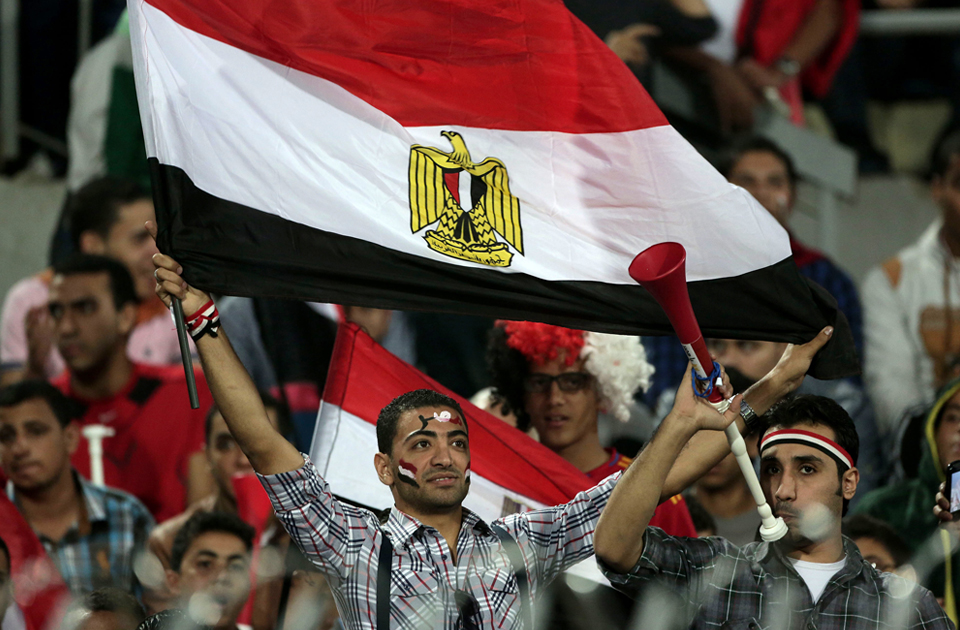An Egyptian supporter waves a national flag during the World Cup qualifying playoff second leg soccer match, at the Air Defense Stadium in Cairo, Egypt, Tuesday, Nov. 19, 2013 (Photo: AP)