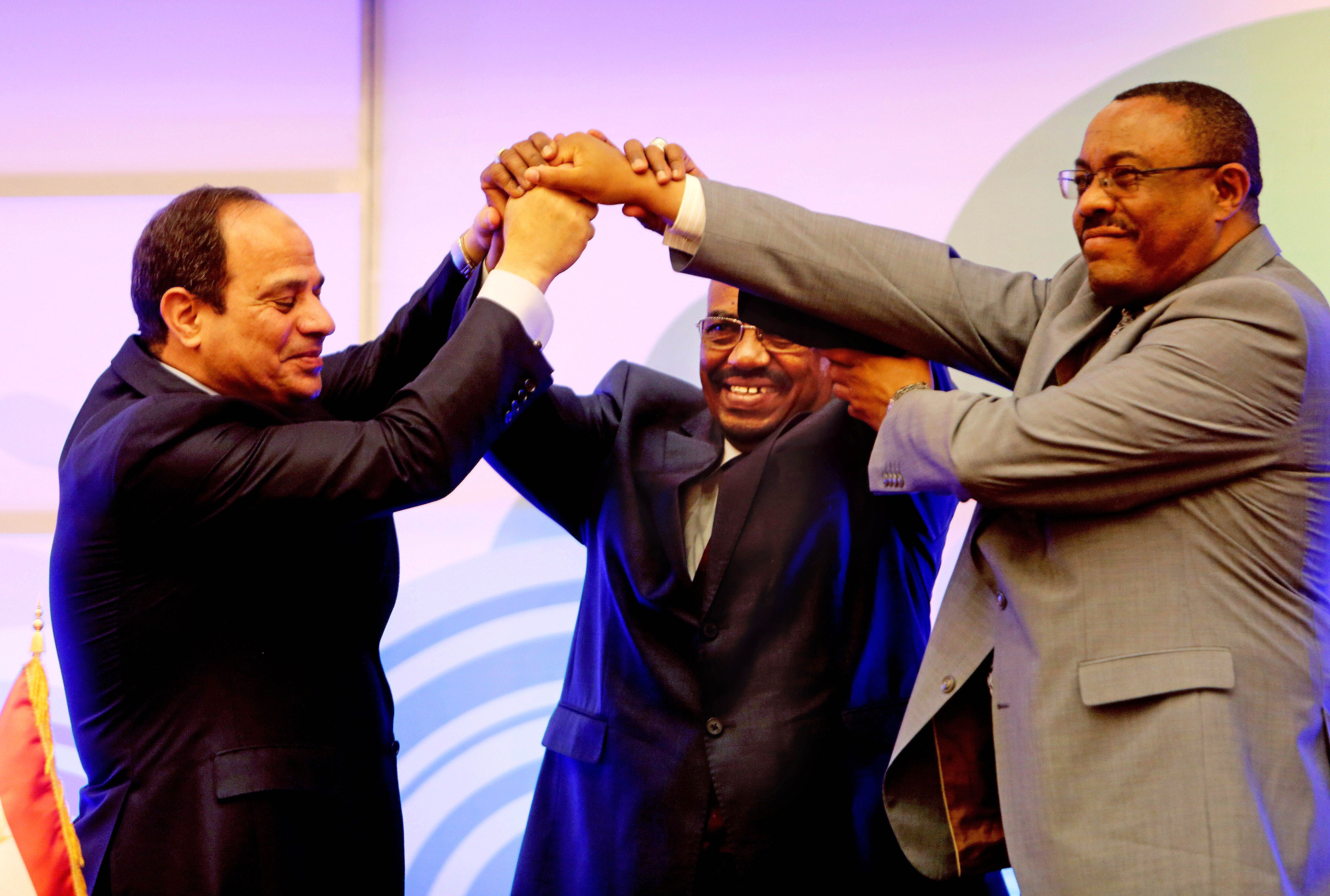 Sudanese President Omar al-Bashir, center, Egyptian President Abdel-Fattah el-Sissi, left, and Ethiopian Prime Minister Hailemariam Desalegn, right, hold hands after signing an agreement on sharing water from the Nile River, in Khartoum, Sudan, Monday, March 23, 2015. Egypt, Ethiopia and Sudan on Monday signed an initial agreement on sharing water from the Nile River that runs through the three countries, as Ethiopia constructs a massive new dam it hopes will help alleviate its electricity shortages. El-Sissi, al-Bashir and Desalegn welcomed the agreement in speeches in Khartoum’s Republican Palace on Monday. (AP Photo/Abd Raouf)