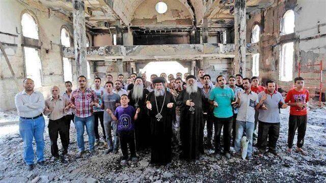 Coptic Christians pray in a burned church in Egypt. 