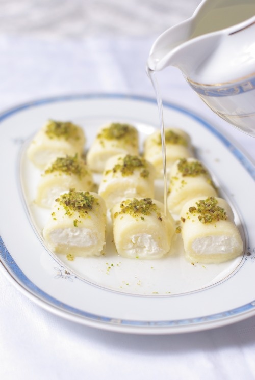 Halawat Al Jibn with syrup poured over and garnished with pistachio.
