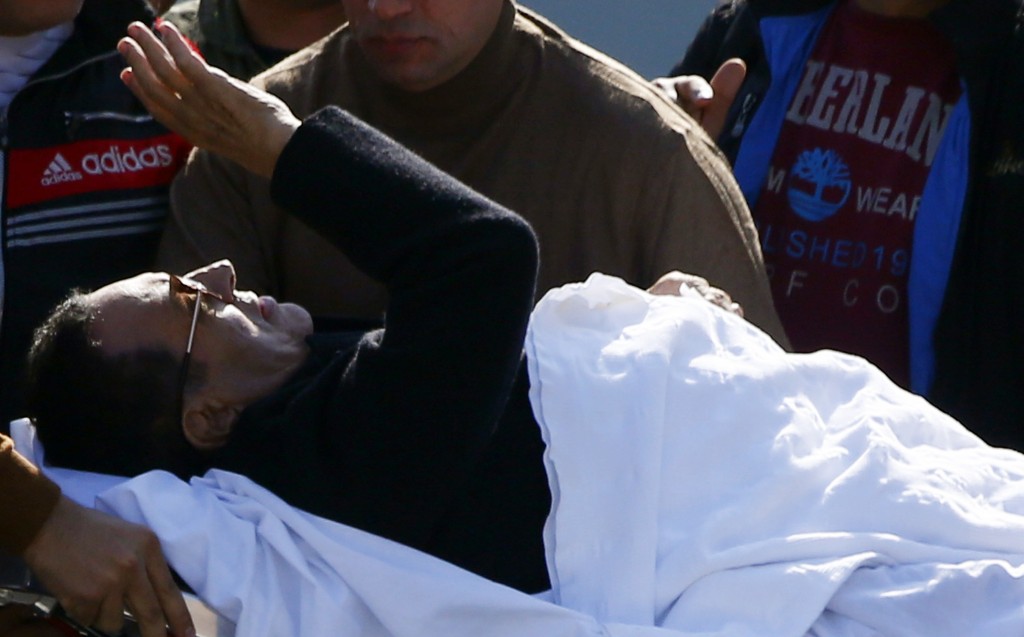 Former Egyptian President Hosni Mubarak waves to his supporters from his stretcher as he returns to Maadi military hospital in Cairo November 29, 2014. REUTERS/Amr Abdallah Dalsh