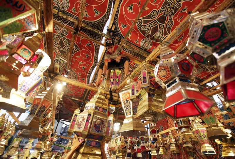 A vendor hangs Ramadan lanterns (or Fanoos Ramadan) that are displayed for sale at a shop ahead of the Muslim fasting month of Ramadan in Cairo. Credit: Mohamed AbdelGhany/Reuters