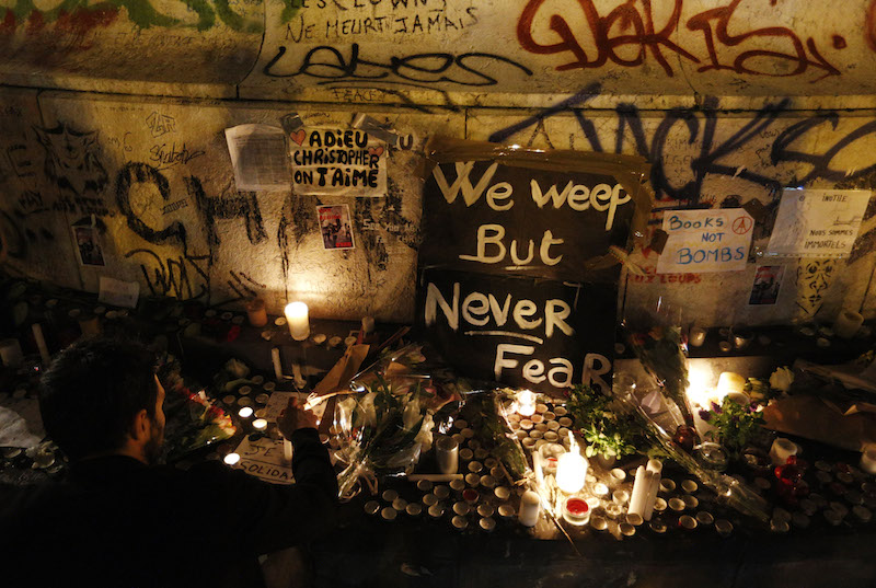 A man lights a candle in Republique square in Paris Nov. 14 2015 in memory of victims of terrorist attacks. Coordinated attacks the previous evening claimed the lives of 129 people. The Islamic State claimed responsibility. (CNS photo/Paul Haring)