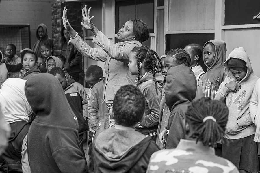 Teacher educates children about personal hygiene during the morning line