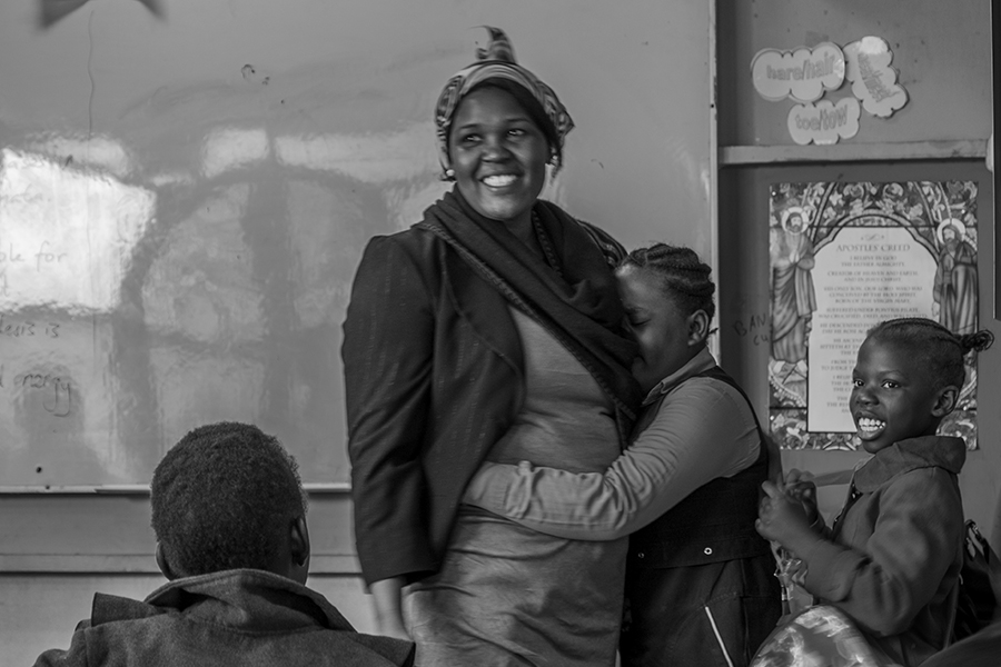 A girl cries and hugs her teacher